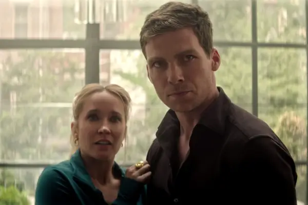 Anna Camp as Maddie Lockwood, Pete Ploszek as Harrison in You season 5 looking shocked as they stand in a conservatory.