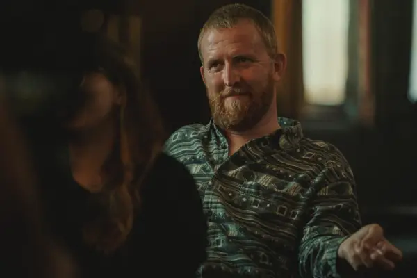 Tom Goodman-Hill sat as Darrien in Baby Reindeer in a green shirt