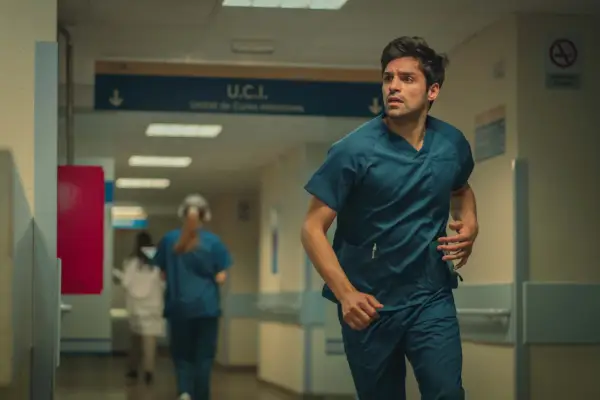 Sean Teale plays Jordi in Who is Erin Carter? in scrubs, running down a hospital corridor