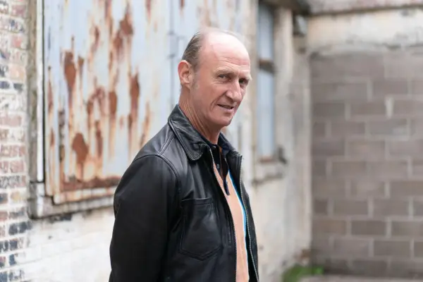 Cafferty standing on an industrial estate, looking at the camera