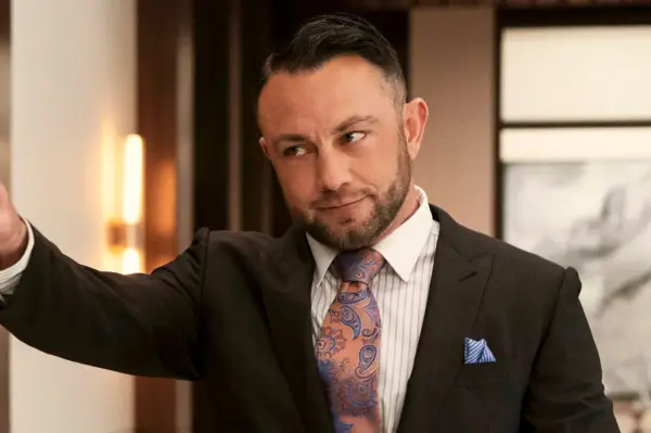 Devon at work standing in front of a Christmas tree and pointing at Cooper