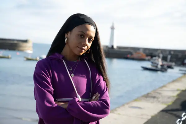 Sade Malone as Taylor Quinn in Hope Street, stood by the seafront and looking at the camera