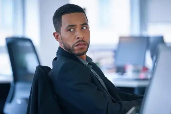 Ukweli Roach as Jack Caffery in Wolf, sitting in an office chair