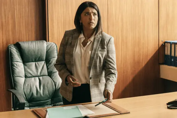 Sunetra Sarker plays DCI Maiya Goswami, standing at her desk in her office