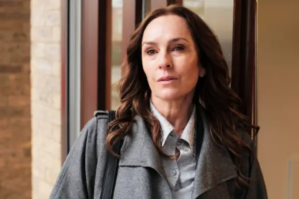 Juliet Aubrey plays Christina Brand, standing outside, wearing a grey coat