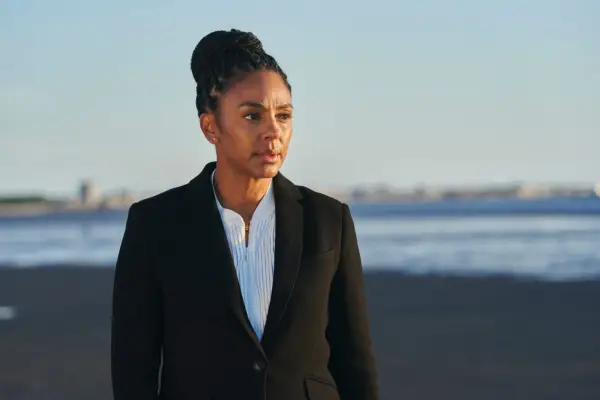 Marsha Thomason in The Bay, wearing a suit and standing on a beach