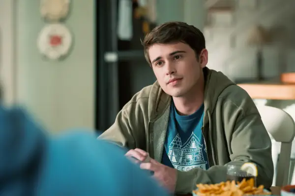 Logan Allen as Kyle, sat at a kitchen table talking to someone