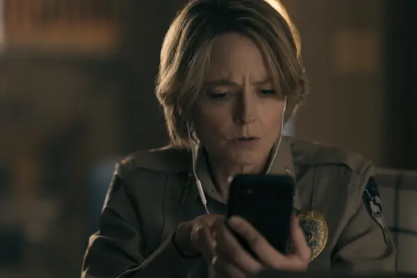 Jodie Foster has a shocked facial expression as she looks at her phone in a scene from True Detective: Night Country