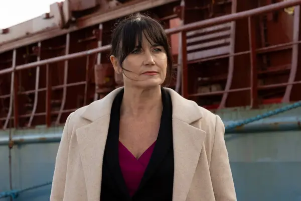 Dawn Steele as DCI Cora Macmillan in Granite Harbour standing outside in a shipyard wearing a coat and looking stresed.
