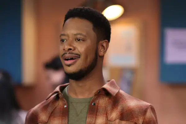 Arjay Smith as James Murray in The Rookie wearing a plaid shirt and green t-shirt.