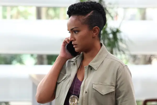 Mekia Cox as Nyla Harper in The Rookie wearing a khaki shirt and answering the phone.