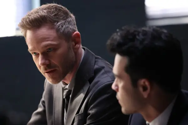 Shawn Ashmore as Wesley Evers in The Rookie sitting in a grey suit as a man looks at him