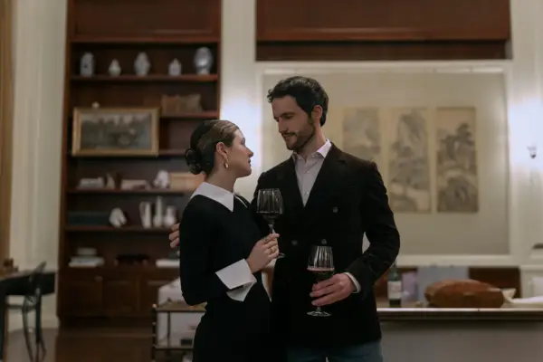 Elise Kibler as Sloane and Rob Heaps as Tomas Bala in The Night Agent, holding wine glasses