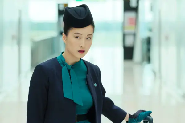 Tiffany walking through the airport in her air stewardess uniform