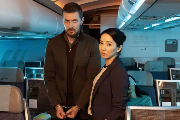 Jing Lusi as DC Hana Li and Richard Armitage as Dr Matthew Nolan in Red Eye standing together on a plane, with Armitage in handcuffs