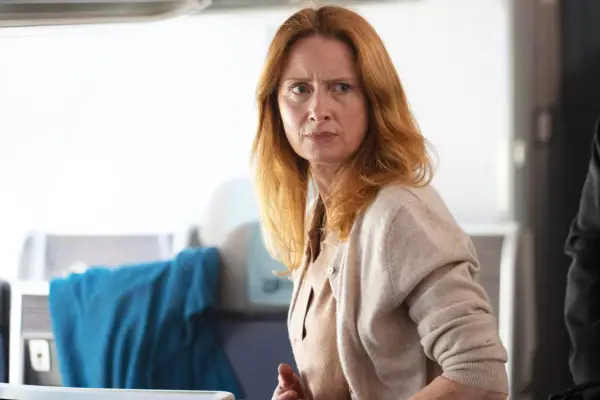 Elizabeth Burk standing up in the plane, with a concerned look on her face