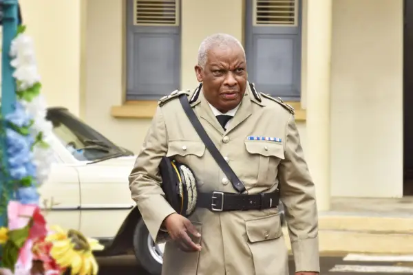 Don Warrington as Selwyn Patterson, walking while wearing his police uniform