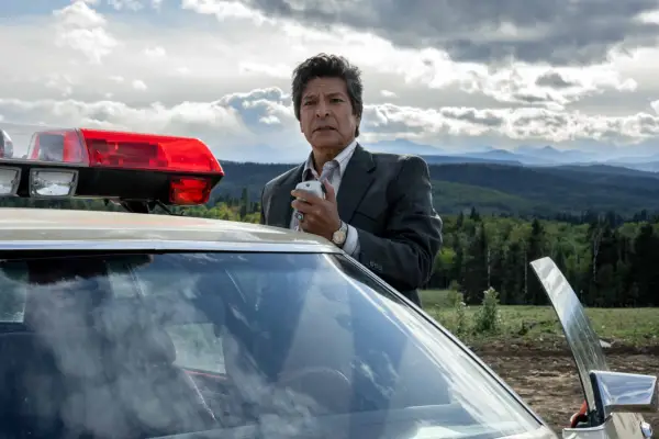 Gil Birmingham as Bill Taba, stood by a police car and holding a radio in Under the Banner of Heaven