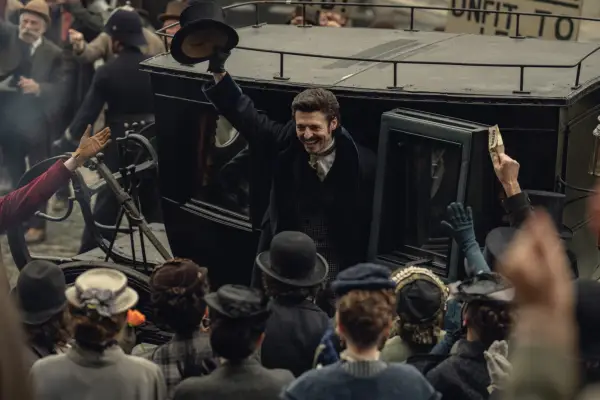 Anthony Boyle stars in House of Guinness; his character is seen here exiting a late 1800s-style automobile and greeting a crowd outside