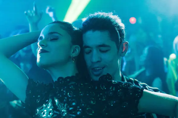 Nick Mohammed in Slow Horses, wearing a suit and stood in front of a blue banner referring to London.