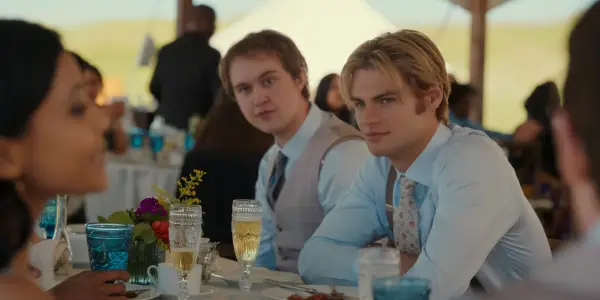 Connor Stanhope as Danny and Noah LaLonde as Cole sat down next to each other in matching wedding attire, smiling.