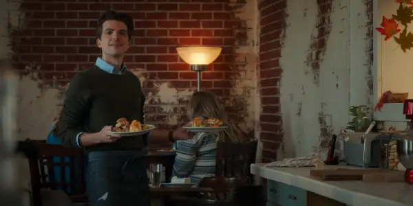 Johnny Link as Will holding a plate of food as he smiles at someone ahead of him.