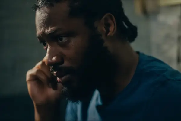 Tom Moutchi as Errol Mathis in Criminal Record in a blue shirt on the phone