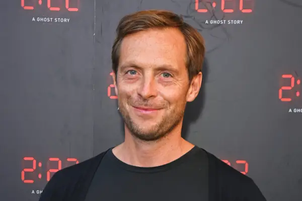 Stephen Campbell Moore wearing a black outfit, smiling