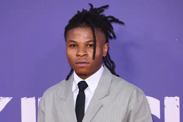 Rasaq Kukoyi wearing a grey suit with white shirt and black tie