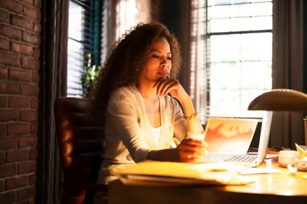 adult Taissa sat at a table reading a document