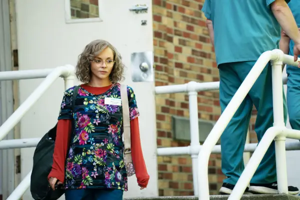 Misty in her work uniform walking down the stairs outside