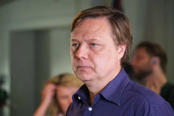 Shaun Dooley as Michael Rudkin, standing in front of a large group, addressing them