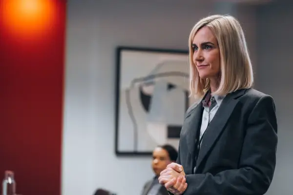 Katherine Kelly as Angela in Mr Bates vs the Post Office wearing a suit and clasping her hands