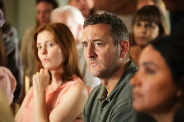 Will Mellor as Lee Castleton, sat down with other people
