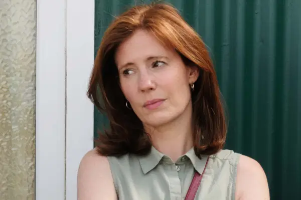 Amy Nuttall as Lisa Castleton, standing outside against a green wall