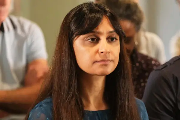 Krupa Pattani as Saman Kaur, sitting down in a large group
