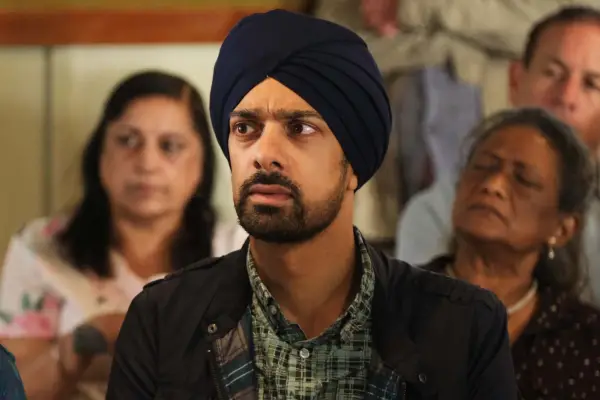 Amit Shah as Jasgun Singh, sitting down in a large group