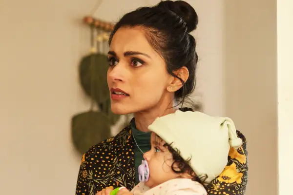 Bhavna Limbachia as Geri Farman-Hoyle, holding a child, she looks scared