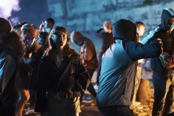 Kelly in the middle of a beach party with a number of people surrounding her.