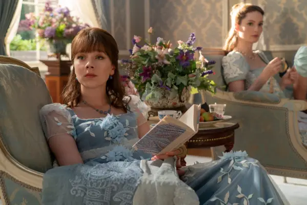 Claudia Jessie as Eloise Bridgerton sat reading a book in Bridgerton season 3.
