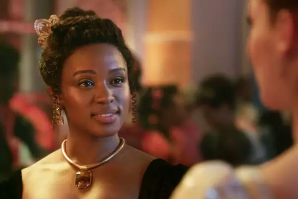 Masali Baduza as Michaela Stirling in Bridgerton season 3. She is wearing Regency-era formal attire, with her hair in an up-do.
