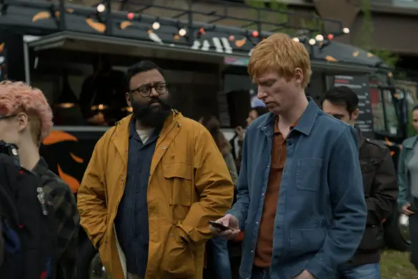Sunil Patel and Domhnall Gleeson in Alice & Jack walking through a busy food market