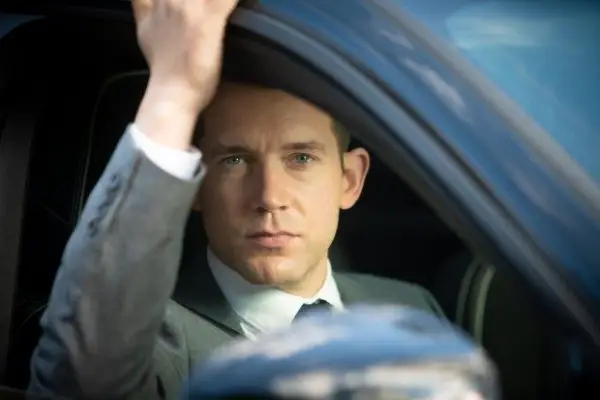Nick Hendrix in Midsomer Murders sitting in a car in a suit
