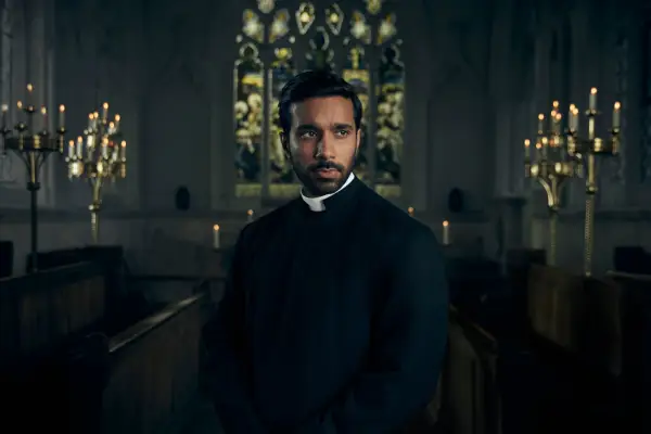 Rishi Nair as Reverend Alphy Kotteram in Grantchester season 9 standing in a church