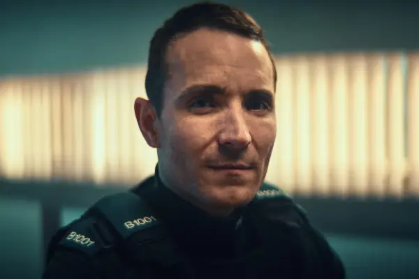 Martin McCann as Stevie Neil in Blue Lights, wearing a police uniform and looking into the camera