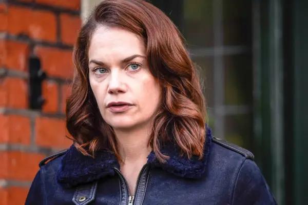 Ruth Wilson as Alice in Luther. She is looking menacing and stood in front of a house.