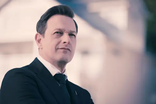 Josh Charles wearing a dark suit