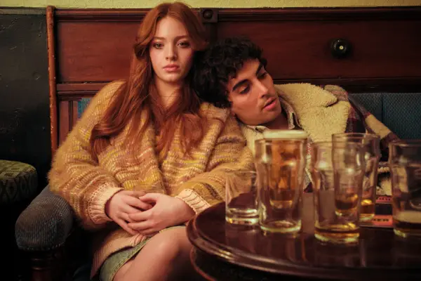 Shervin Alebai as Mehmet Ahah and Rowan Robinson as Katie Wells leaning against each other in the middle of a pub in Passenger.