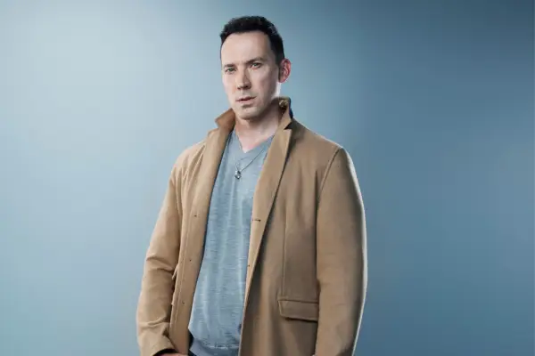 David Caves as Jack Hodgson in Silent Witness dressed in a grey jumper and brown jacket