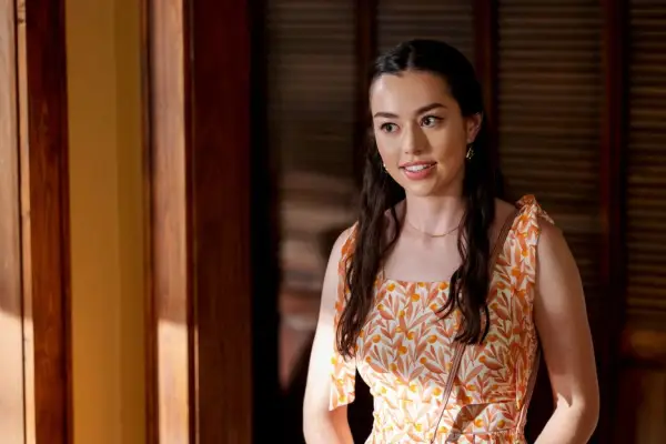 Annie wearing an orange top and smiling